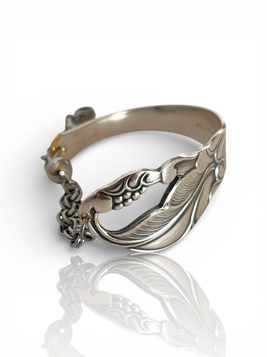 smykke lavet af en sølvske, skeen har et mønster af et blad fra et egetræ.  armbåndet er et helt unikt smykke lavet fra antikt bestik, lavet af Monnas Smykkedesign
