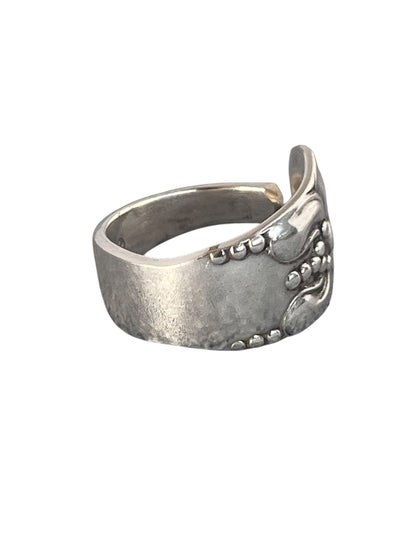 Nærbillede af ring af gammelt bestik med blomstermotiv og rolig overflade i sølvplet, lavet af Monnas Smykkedesign