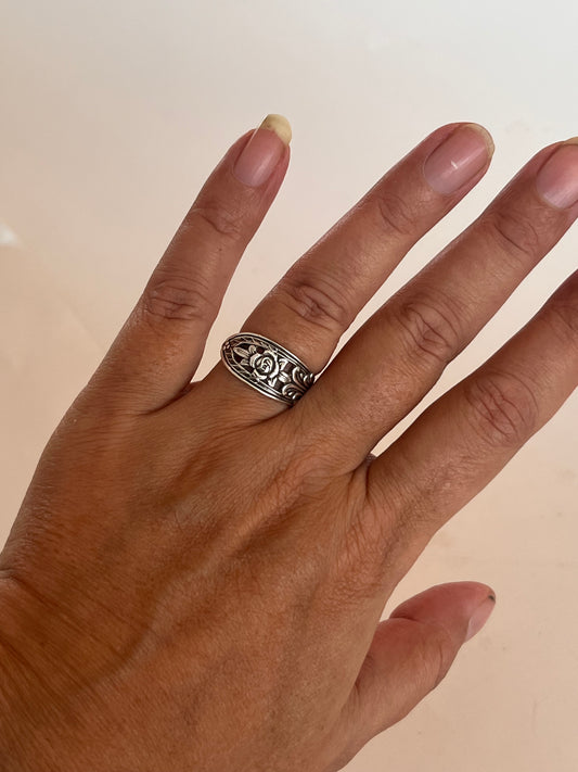 Ring af gammelt bestik båret på hånden, håndlavet genbrugssmykke af antik svensk teske med blomster og hulmønster i skønvirke-stil. Monnas Smykkedesign 